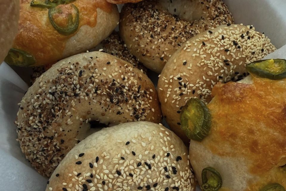 A basket of jalapeño cheddar, everything and sesame sourdough bagels