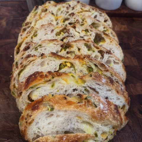 Cheddar jalapeño sourdough sliced on a board