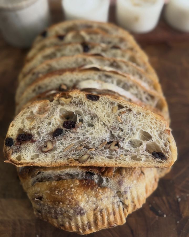 Slices of cranberry walnut sourdough showing an open, airy crumb